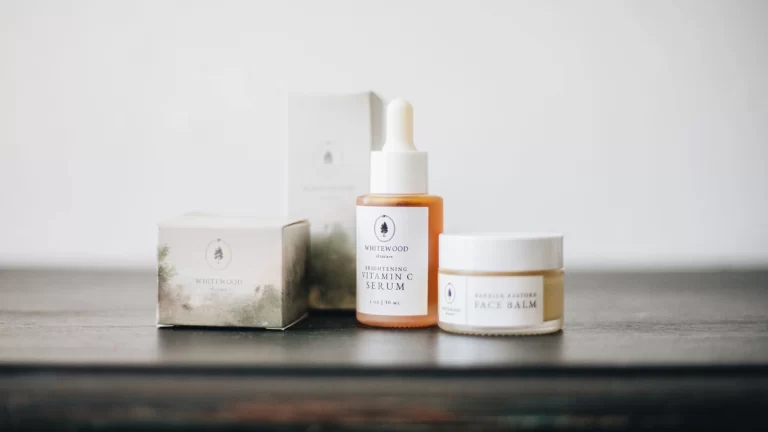 Elegant flat lay of natural skincare products, featuring a vitamin C serum and face balm
