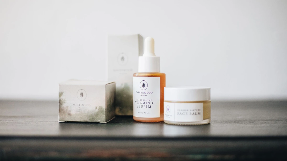 Elegant flat lay of natural skincare products, featuring a vitamin C serum and face balm