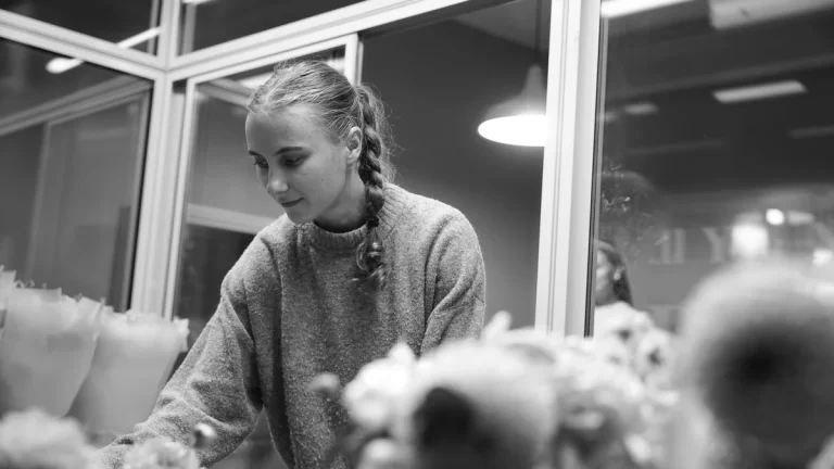 Monochrome a woman arranging flowers indoors with a modern aesthetic. İstanbul, Türkiye